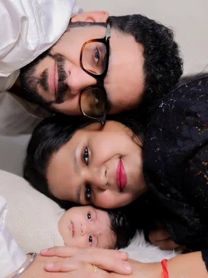 A similar overhead family portrait, this time with the family's heads close together. This composition creates a feeling of closeness and unity, perfectly framing the newborn's sweet face.