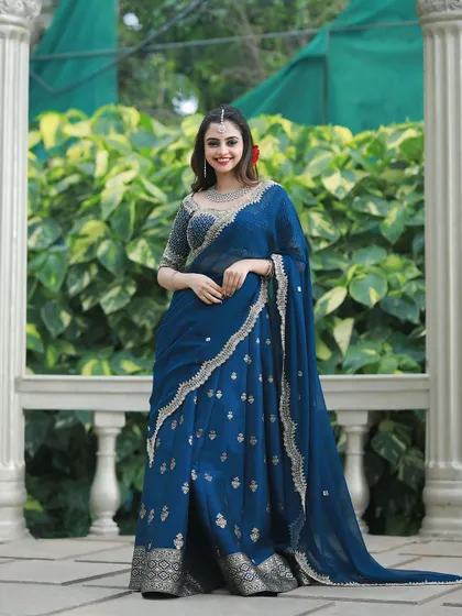 A full-length view of the royal blue lehenga, showing the beautiful flow of the skirt and the delicate sheer dupatta.