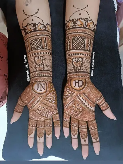 A beautiful example of incorporating the couple's initials into the bridal design. The letters 'J' and 'N' are elegantly placed within the intricate patterns on each palm.
