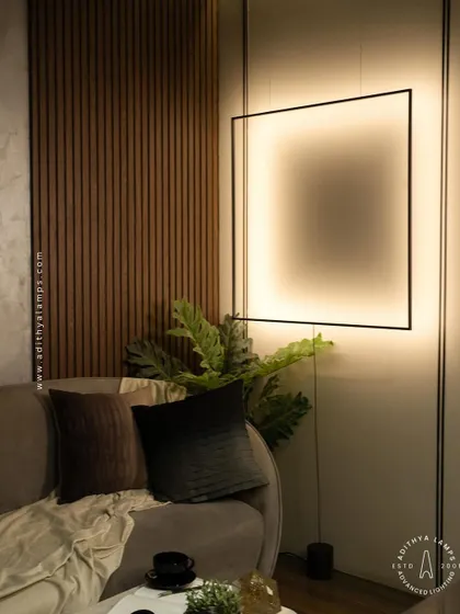 This unique floor-to-ceiling fixture features a large, suspended square frame that washes the wall with a soft, ambient light. It acts as both a light source and a bold, graphic art piece for a contemporary living room.