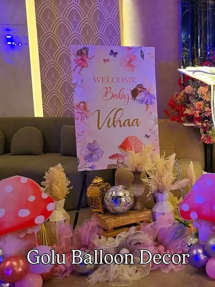 The welcome area for baby Vihaa's party, featuring a fairy-themed sign, mushroom props, and disco balls for a touch of sparkle.