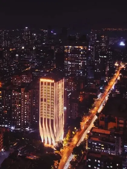 An aerial night view capturing the ID Origins tower within its urban surroundings, demonstrating its role as a visual marker and a piece of modern architecture in Mumbai.