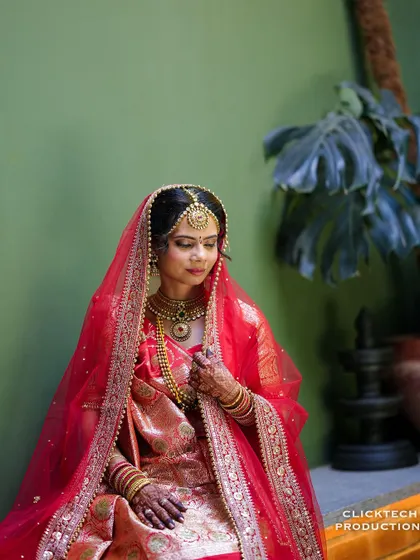 A pensive and beautiful portrait of the bride, her red veil framing her face perfectly.