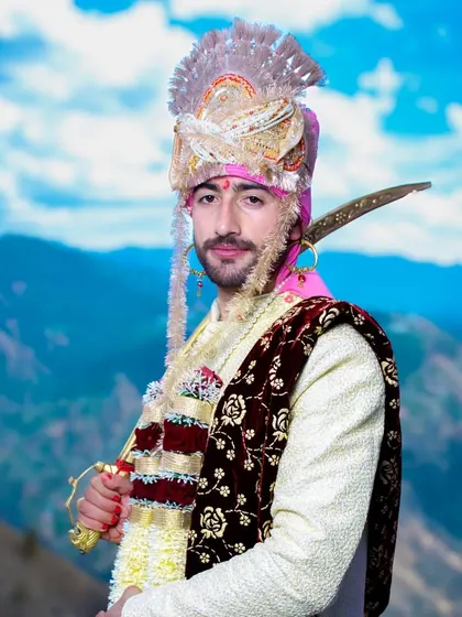 A stylish portrait of the groom in his wedding attire, with the mountains of Himachal creating a stunning backdrop.