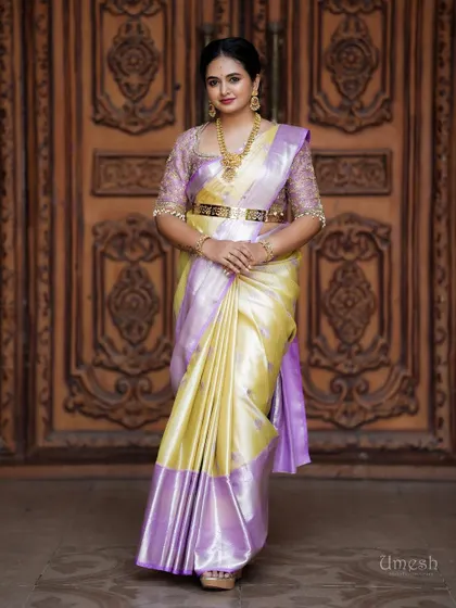 A full-length view of the same look, showcasing a beautiful yellow and lavender silk saree paired with our classic gold jewellery.