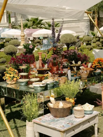 A beautiful grazing table laden with snacks and fruits, artfully arranged amidst fresh flowers and greenery.