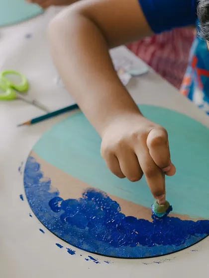 Getting hands-on with finger painting! This young artist is creating waves for his seascape project. We encourage getting a little messy in the name of creativity.