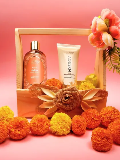 The skincare products are styled with marigold flowers, adding a festive and natural element to the product shot.