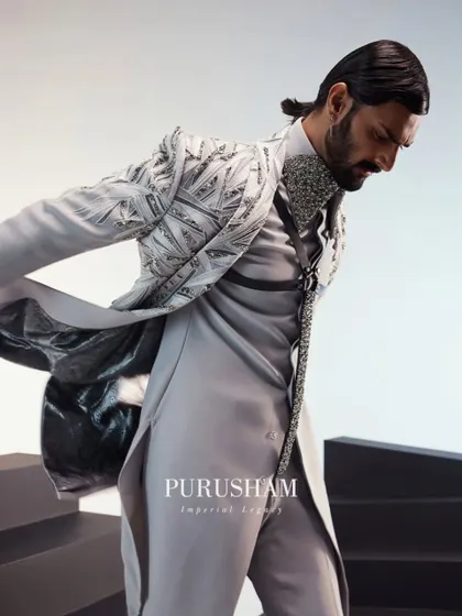 The movement of this grey jacket shows off its unique construction and the contrasting lining. It is a piece designed to be dynamic and visually interesting from every angle.