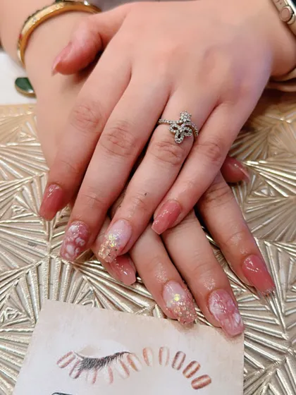 A soft and romantic look with long square nails in a dusty rose color. The accent nails feature a marbled effect with gold foil flakes for a touch of luxury.