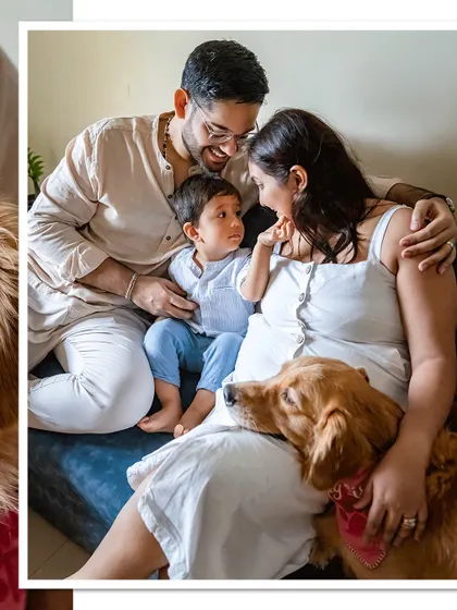 A beautiful family portrait on the couch, with their Golden Retriever looking on as a cherished family member.