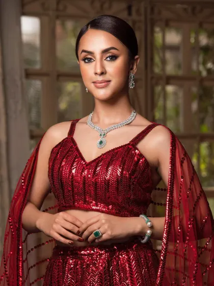 A portrait of ethereal beauty in a sparkling red ensemble, perfect for a cocktail or reception look. The focus is on the soft glam makeup and elegant jewelry.