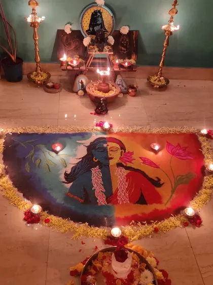 The completed Ardhanarishvara rangoli, decorated with diyas and flowers for Mahashivratri pooja.
