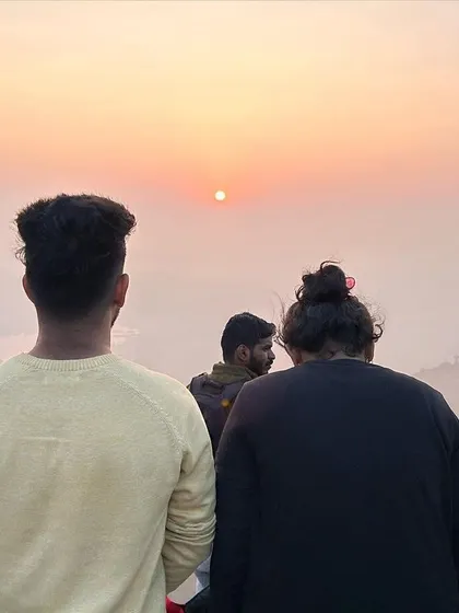 The group watches as the sun begins to rise over the horizon at Huthridurga.