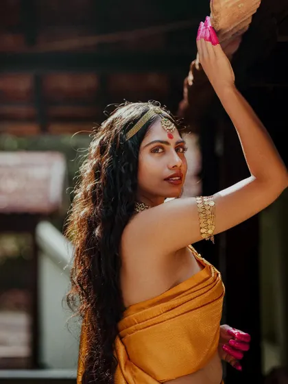 A close-up showing the details of the armlet (bajuband) and the natural, wavy hairstyle.