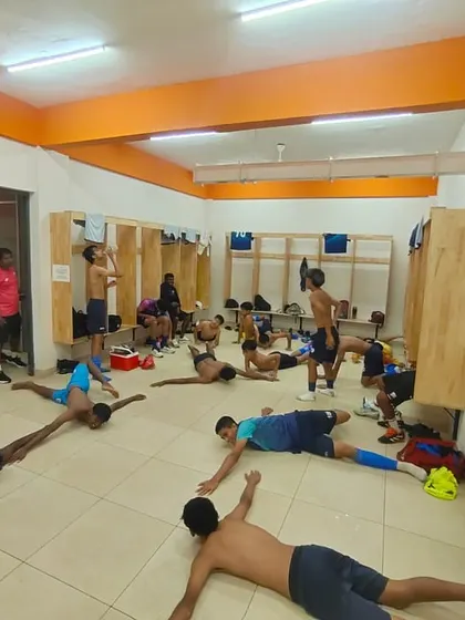 Post-match stretching and recovery in the locker room. Our physios ensure players cool down properly to prevent injuries.