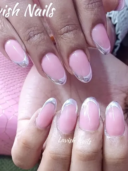 A futuristic French manicure with a metallic silver chrome tip on oval-shaped nails, offering a unique and trendy look.