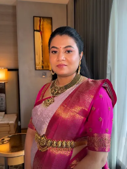 A full-length view of this elegant look. The makeup is designed to look flawless both up close and from a distance, pairing beautifully with her traditional silk saree and temple jewellery.