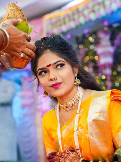 A bride receives blessings during a pre-wedding puja, a coconut symbolizing prosperity and good fortune.
