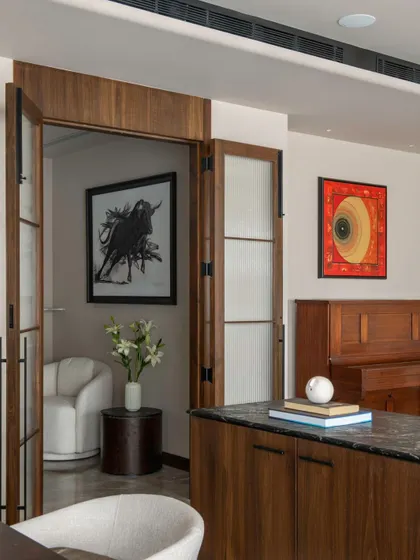 Pocket doors with glass panels separate the formal living area from a more private den in the Parishram residence, allowing for both connection and separation.