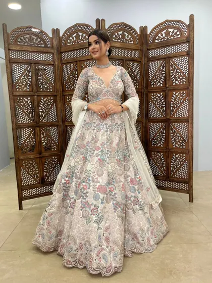 A full, smiling shot of a client looking beautiful in this floral embroidered lehenga.