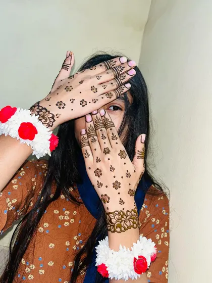 A shy pose showing off the simple and sweet Eid henna. This style is quick to apply but looks very beautiful.