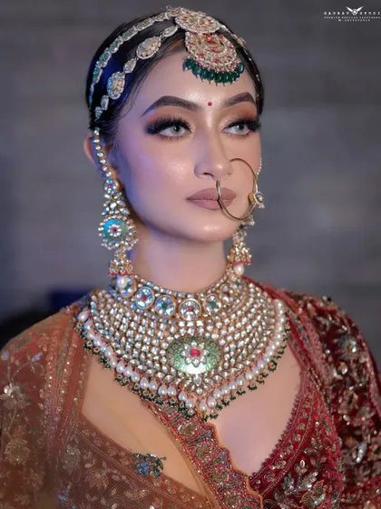 A beautiful beauty shot, highlighting the bride's perfect makeup and the grand scale of her kundan necklace. The lighting is crafted to make the jewellery sparkle.