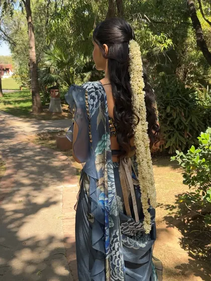 The back view, showing the beautiful hairstyle with a traditional gajra. The hair and makeup work together to create a cohesive and elegant look.