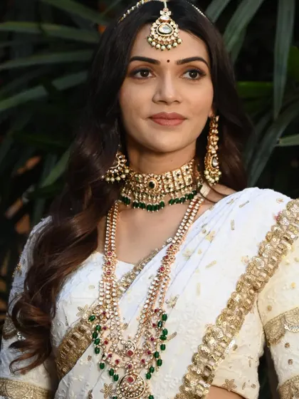 The maang tikka and earrings are designed to perfectly match the necklaces, creating a complete and polished look for any grand occasion.