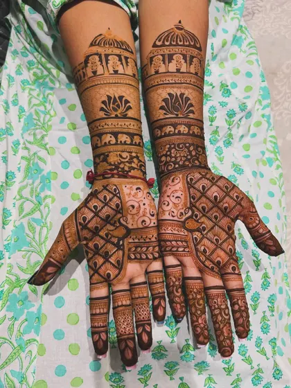 This full bridal design combines a variety of patterns, including jaali (net), floral bands, and traditional elephant motifs near the elbows, creating a rich and textured look.