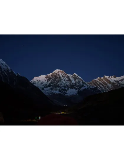 The first light of dawn kisses the peak of Annapurna South. Witnessing the sunrise paint the mountains is a highlight of our base camp treks.