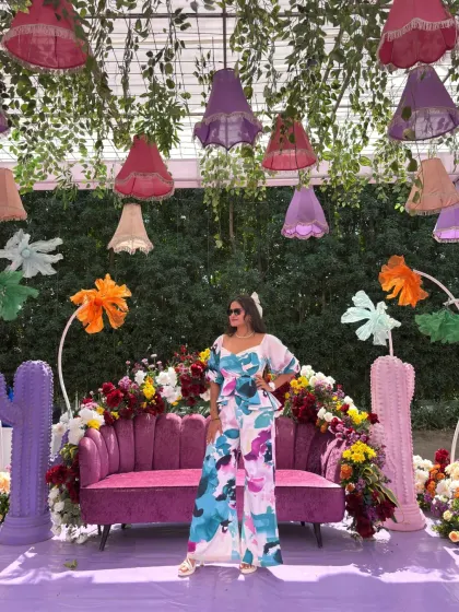 Posing at the vibrant, quirky, and colorful photo booth set up for the wedding carnival.