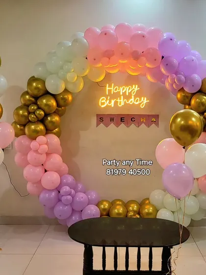 A beautiful pastel rainbow balloon arch with gold accents.