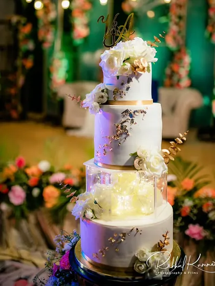 A full view of the four-tier white and gold spacer cake. This design is a perfect example of how we can create a tall, impressive cake that remains elegant and modern.
