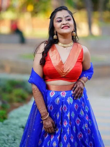 A vibrant blue ikat lehenga paired with a contrasting orange blouse, perfect for a Mehendi or Sangeet ceremony.