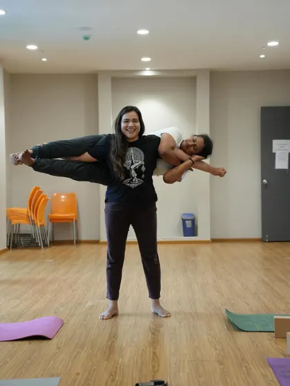 Partner yoga is all about trust, balance, and having fun. Here, I'm supporting a student in a playful flying pose.