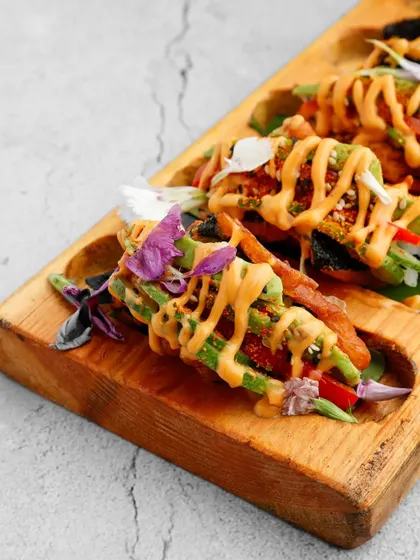 A fusion of Japanese and Mexican cuisine. Our crispy sushi tacos feature a crunchy shell filled with seasoned rice and fresh vegetables, drizzled with a tangy sauce for a truly unique appetiser.