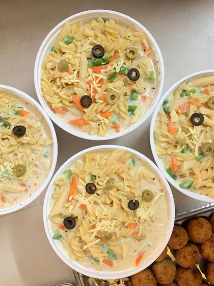 A close-up of the creamy White Sauce Pasta, loaded with veggies and olives. A favorite among all age groups.