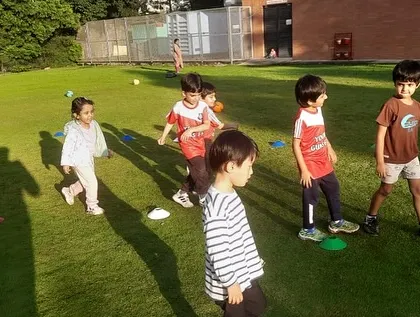 The long shadows of an evening practice create a dramatic scene. Our players are focused as they move through a cone drill, showing their dedication.