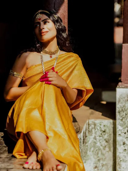 A sun-kissed shot from the 'Thamara' series, with the golden-yellow saree glowing in the light.