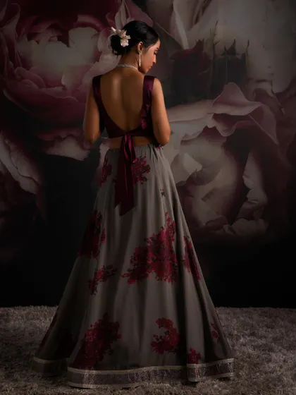 The back of this ensemble features a deep, tie-back velvet blouse, offering a modern and alluring contrast to the printed floral lehenga skirt.