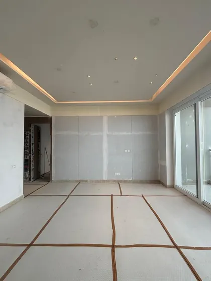 The bare living room of the Conscient Parq project, with markings on the floor for furniture placement, showing the blank canvas before transformation.