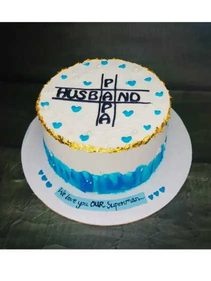 A cake celebrating a man who is both a husband and a papa. This chocolate truffle cake features a crossword design and is dedicated to "Our Superman."
