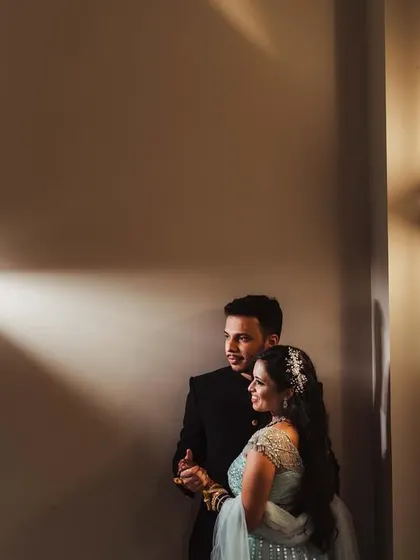 A beautifully lit portrait in a hallway, using wall sconces to create pools of light. This shot of Shweta and Onkar has a cinematic and intimate feel.