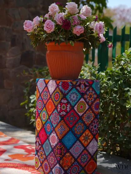 We love to play with patterns and textures. This floral arrangement is placed on a pedestal covered in a vibrant, multi-colored fabric, adding a pop of modern design to the traditional Haldi decor.