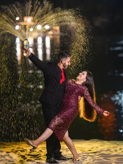 Let's celebrate your love with a bang. A champagne pop at night on the sandy banks of the river creates a fun, celebratory, and dynamic shot that’s full of joy and energy.