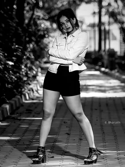 A confident and stylish pose, this black and white outdoor shot has a modern, high-fashion feel.