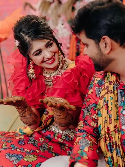 Fun and candid moments from a vibrant Mehendi event. The couple is sharing a laugh, surrounded by the bright, festive atmosphere I designed for their special day.