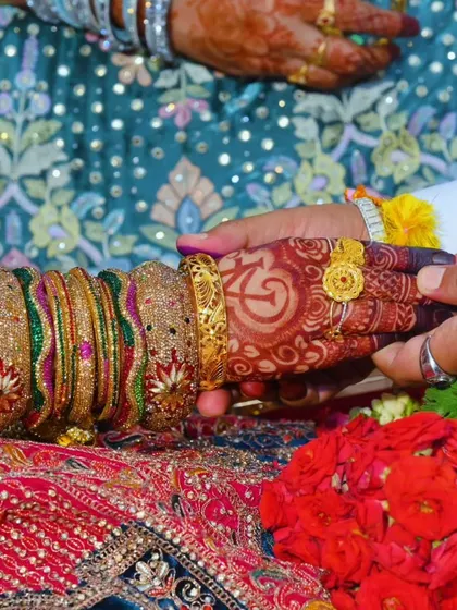 A beautiful candid moment from a wedding, where the bride's dark mehndi is the star of the show.