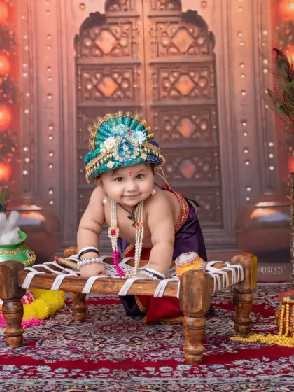 I capture your baby's crawling stage with this adorable shot on a miniature cot. Dressed as Krishna, your child's innocent smile is the highlight of this cultural heritage photography session.